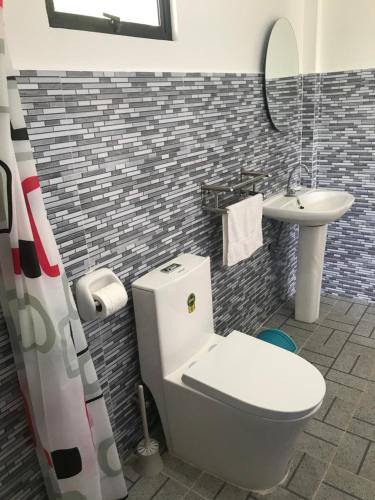 a bathroom with a toilet and a sink at Paradise Beach Guest House in Bantayan Island