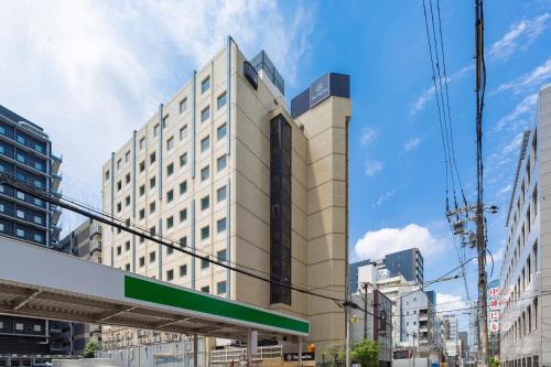 a tall building with a sign in front of it at The OneFive Osaka Sakaisuji in Osaka