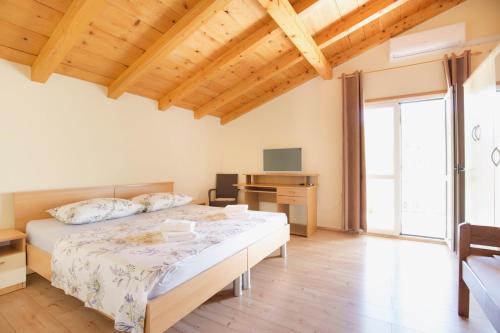 ein großes Schlafzimmer mit einem Bett und einem Schreibtisch in der Unterkunft Apartment Josipa in Vis