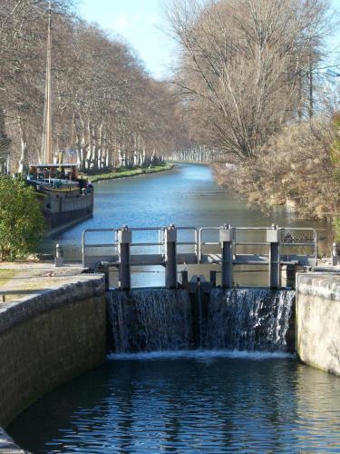 a water fall in a river with a bridge at Mas de Bellegou in Portiragnes