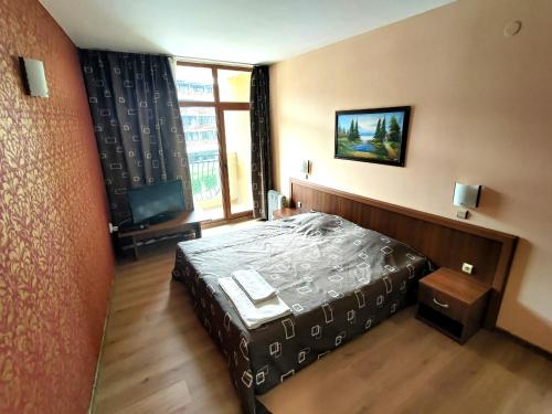 サニービーチにあるGrenada.Suite.tonight.1 bedroom.pool view.300m to beachのベッドと大きな窓のある寝室