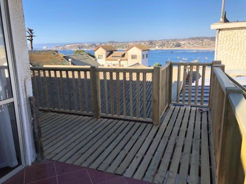 a wooden deck with a view of the ocean at Altomiramar in El Quisco