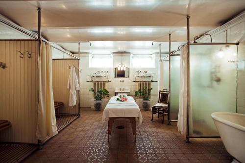 a bathroom with a table and a bath tub at Bårdshaug Herregård in Orkanger