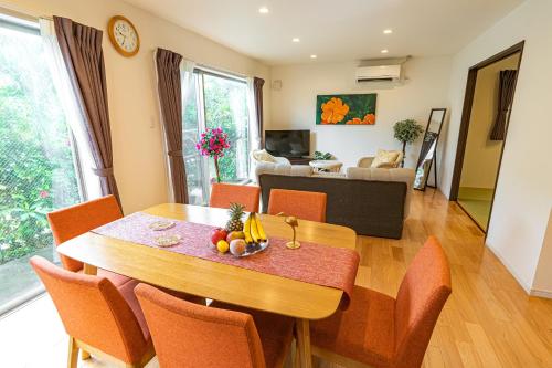 een eetkamer en een woonkamer met een tafel en stoelen bij Palm Springs Miyakojima Resort in Miyako Island