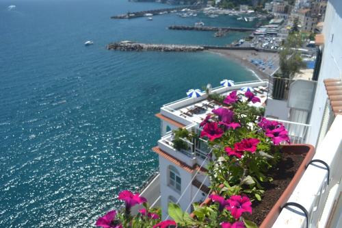 a view of the ocean from a balcony with flowers at Donna Giulia in Amalfi