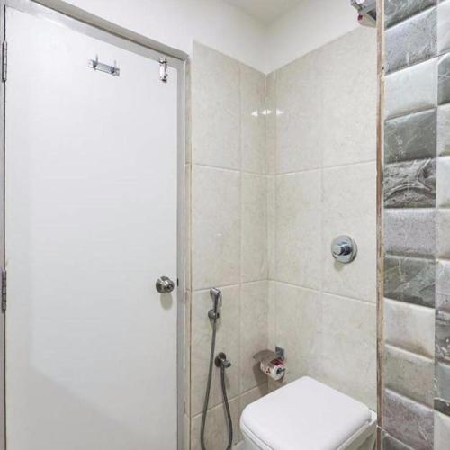 a bathroom with a shower with a toilet and a sink at La Riviera Suites in Hyderabad