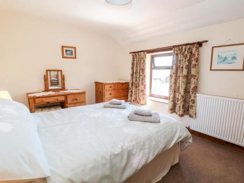 a bedroom with a bed with two towels on it at Keepers Cottage in Chapel en le Frith