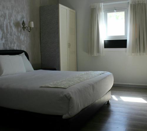 a bedroom with a large bed with a window at Hotel Alma - Near The Sea in Netanya