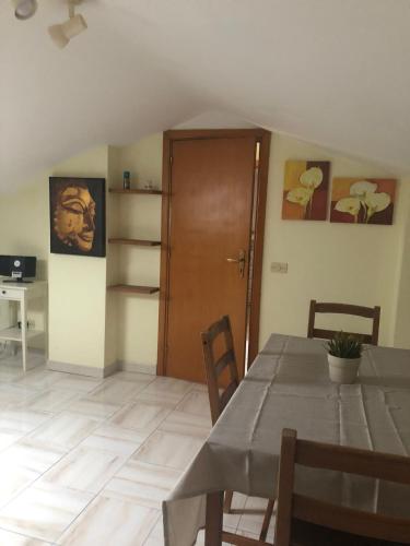 a dining room with a table and a wooden door at Appartamentino Mansardato in Pedara
