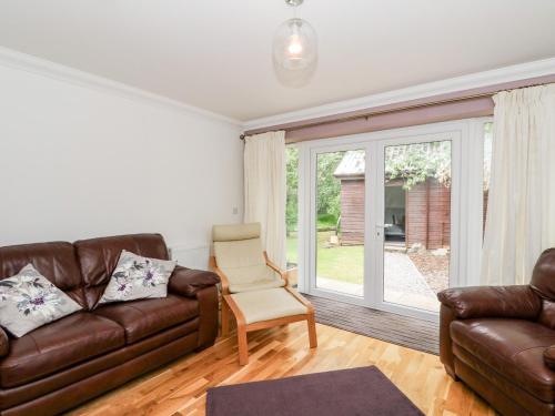 a living room with a leather couch and a chair at Tigh Na Drochit in Garve