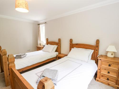a bedroom with two beds and a night stand at Tigh Na Drochit in Garve