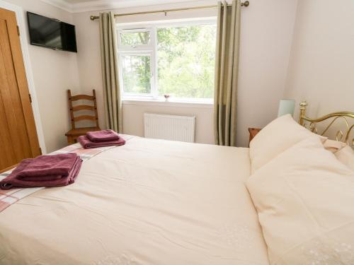 a bedroom with a bed with two towels on it at Tigh Na Drochit in Garve