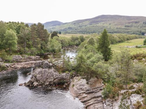 a view of a river with trees and rocks at Tigh Na Drochit in Garve