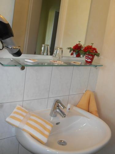 a bathroom with a white sink and a mirror at Hotel Brückentor in Rinteln