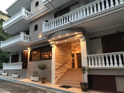 une grande maison blanche avec un escalier en face de celle-ci dans l'établissement Hotel Kastri, à Loutra Edipsou