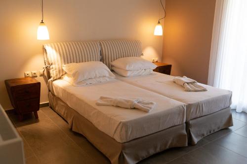 a bedroom with a bed with two towels on it at Karya Villas in Kariá