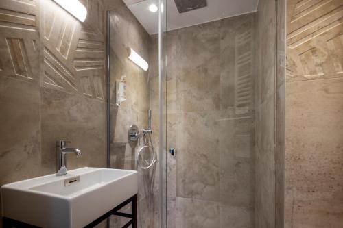 
a bathroom with a shower, sink, and mirror at Grand Hôtel Lévêque in Paris
