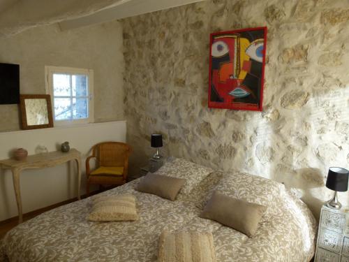 une chambre avec un lit et un tableau au mur dans l'établissement chambre campagnarde, à Bargème