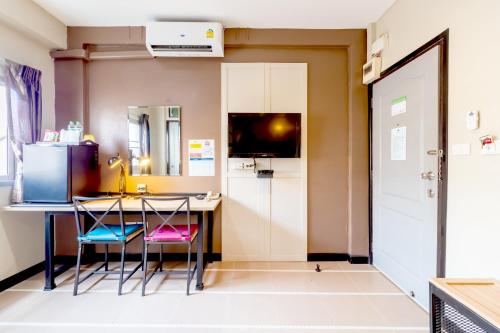 a kitchen with a table and chairs in a room at The Palm Hotel in Salaya