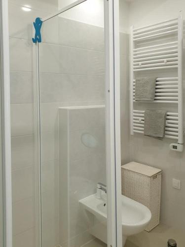 a white bathroom with a shower and a sink at IDIS Holiday Home in Omiš