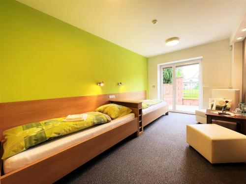 a bedroom with two beds and a green wall at Výšinka 719 in Turnov