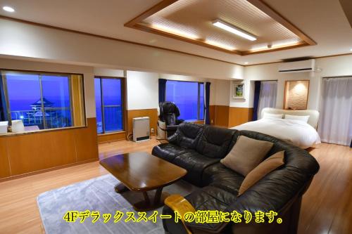 a living room with a couch and a bed at Mujuan in Atami