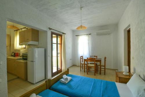 a kitchen and living room with a refrigerator and a table at Galini Apartments in Achlia