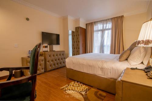 a hotel room with a bed and a television at The Grand Palace Hotel in Addis Ababa