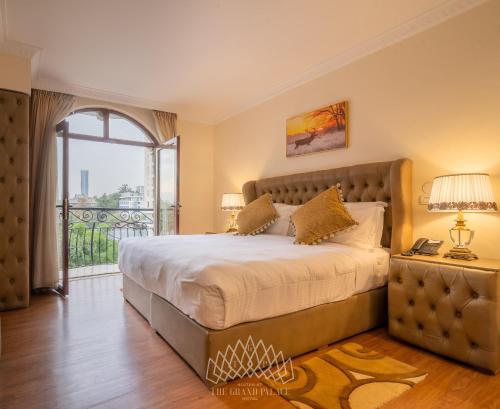 a bedroom with a large bed and a balcony at The Grand Palace Hotel in Addis Ababa