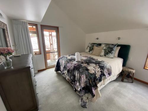 a bedroom with a bed and a tv in it at Glacier Rock Lakeview House in Lake Tekapo