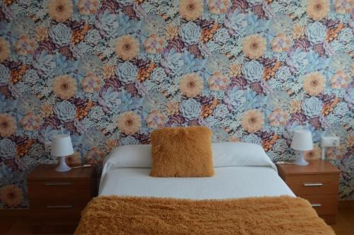 een slaapkamer met een bed met bloemrijk behang bij Hostal Solymar in Louro