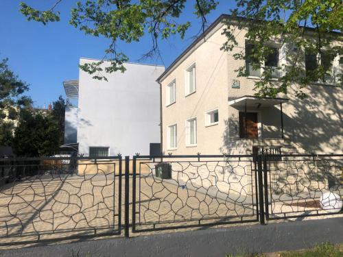 a fence in front of a white building at Apartament Słoneczny Willa Perla 100m od morza in Gdańsk