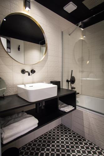a bathroom with a sink and a mirror and a tub at Hôtel Restaurant Vaillant proche Europapark Rulantica in Sélestat