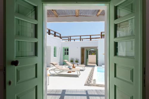 an open door to a patio with chairs and a pool at Dipagio Origin Villa in Lachania