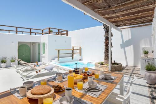 a dining room with a table and a pool at Dipagio Origin Villa in Lachania