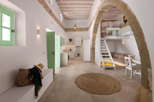 a kitchen and a living room with a spiral staircase at Dipagio Origin Villa in Lachania