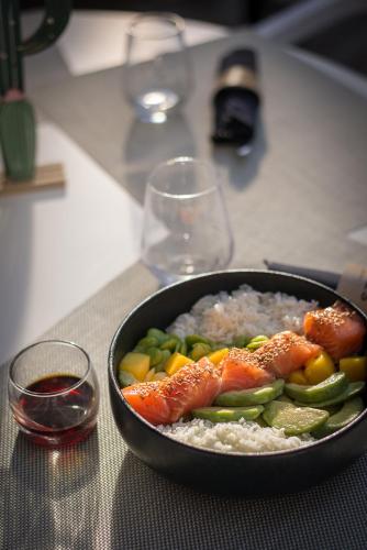 a bowl of rice with salmon and vegetables on a table at Hôtel Restaurant Vaillant proche Europapark Rulantica in Sélestat