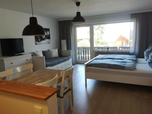 een slaapkamer met een bed, een tafel en een bank bij Ferienwohnung Alpenspaß in Missen-Wilhams