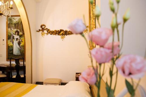 a mirror with pink flowers in front of a bed at Domus Socolatae Residenza d'Epoca Charming B&B - Adults Only in Follonica