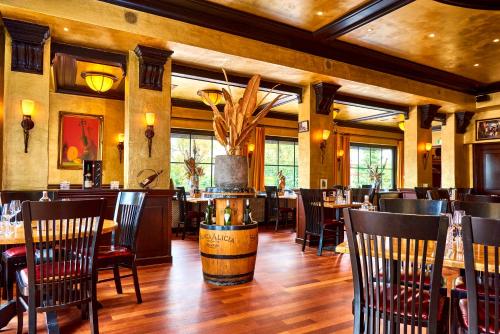 a restaurant with wooden floors and tables and chairs at Hotel VILLA GROET in Avenhorn