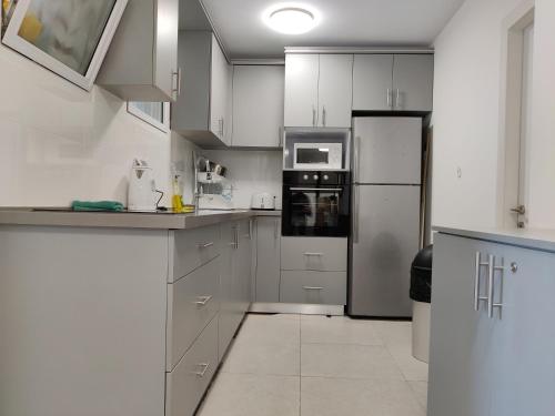 a kitchen with white cabinets and a refrigerator at Dizengoff Penthouse Boutique Hostel in Tel Aviv