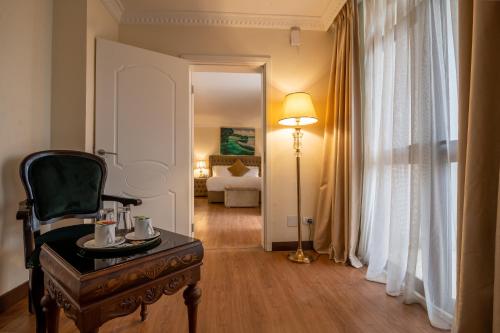 a living room with a chair and a table and a lamp at The Grand Palace Hotel in Addis Ababa