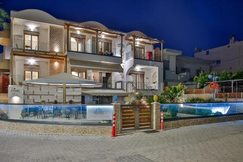um grande edifício com uma piscina em frente em Elimia Suites & Studios em Makry Gialos