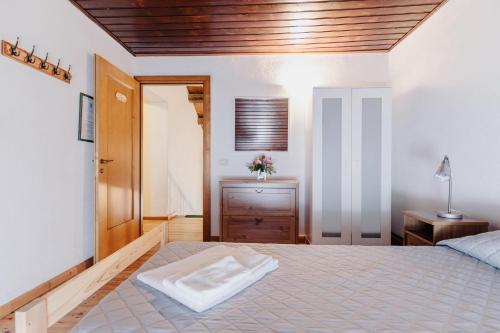 a bedroom with a large bed with a wooden ceiling at Fondazione Lucia De Conz in San Gregorio nelle Alpi,
