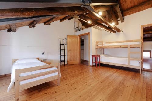 a bedroom with two bunk beds and a wooden floor at Fondazione Lucia De Conz in San Gregorio nelle Alpi,