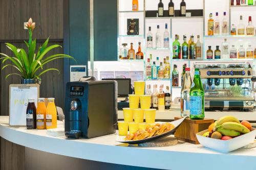 a counter with a bar with food and drinks at Golden Tulip Marseille Euromed in Marseille