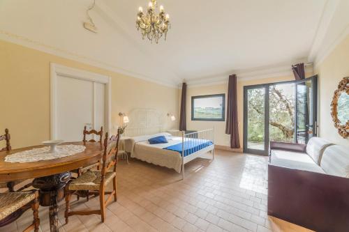 a living room with a dining room table and a bedroom at Agriturismo SS Annunziata in San Vincenzo