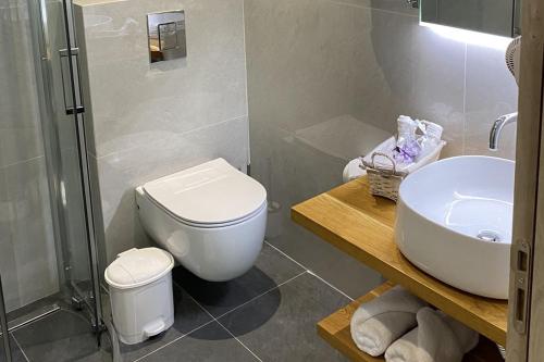 e bagno con servizi igienici, lavandino e doccia. di Oliva Suites a Keramotí