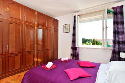 1 dormitorio con cama morada y ventana en Apartments Bella Vista Split en Split