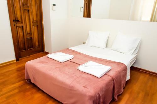 a bedroom with a bed with two towels on it at Bohemian Apartment - Center of Bucharest in Bucharest